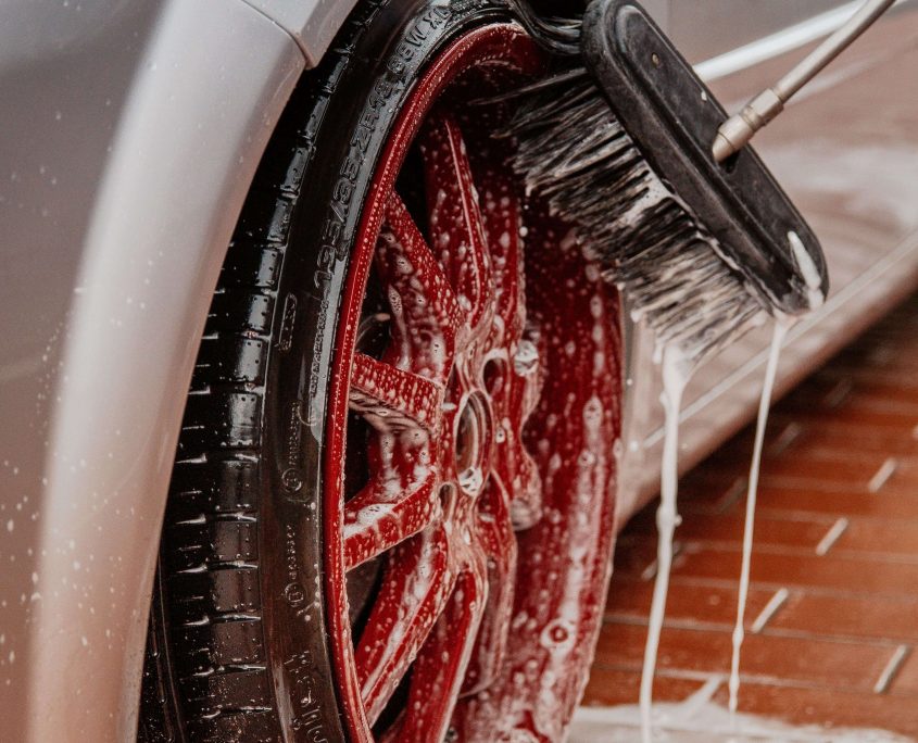 Car wheel being scrubbed with brush
